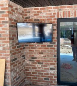 TV mounted in corner on brick